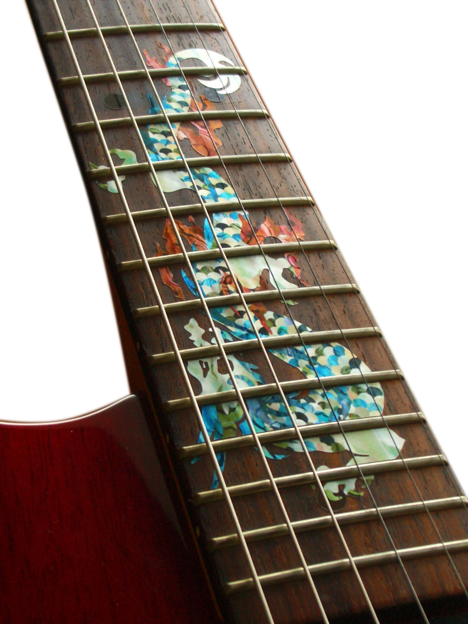 Close-up of a guitar's fretboard with a white dragon inlay pattern