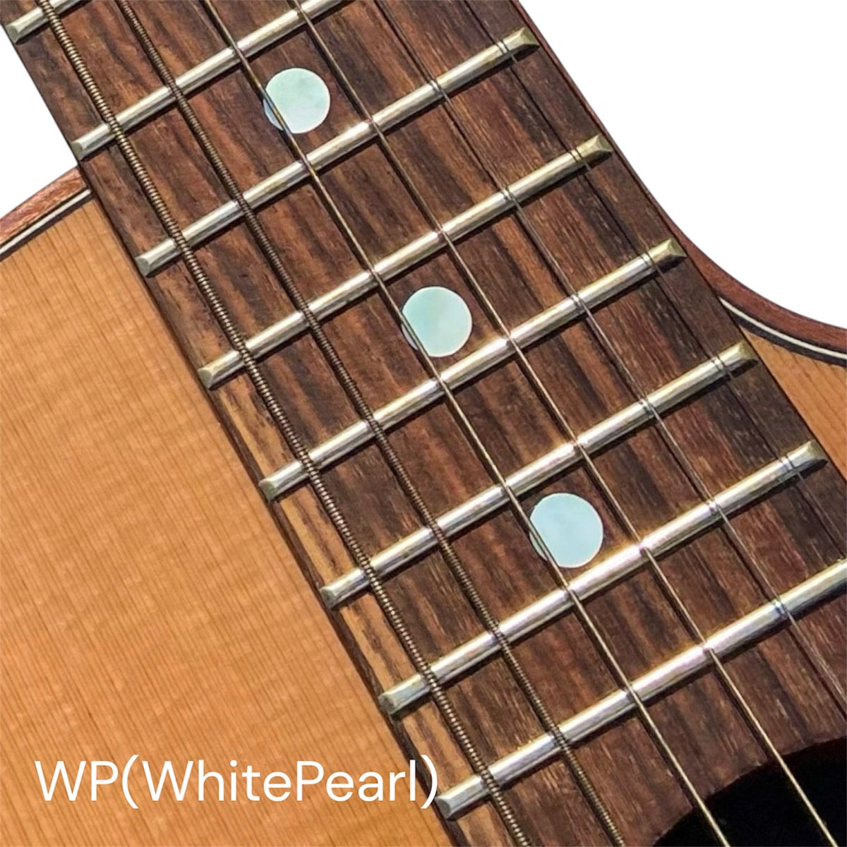 Close-up of a guitar fretboard with white dot inlay stickers