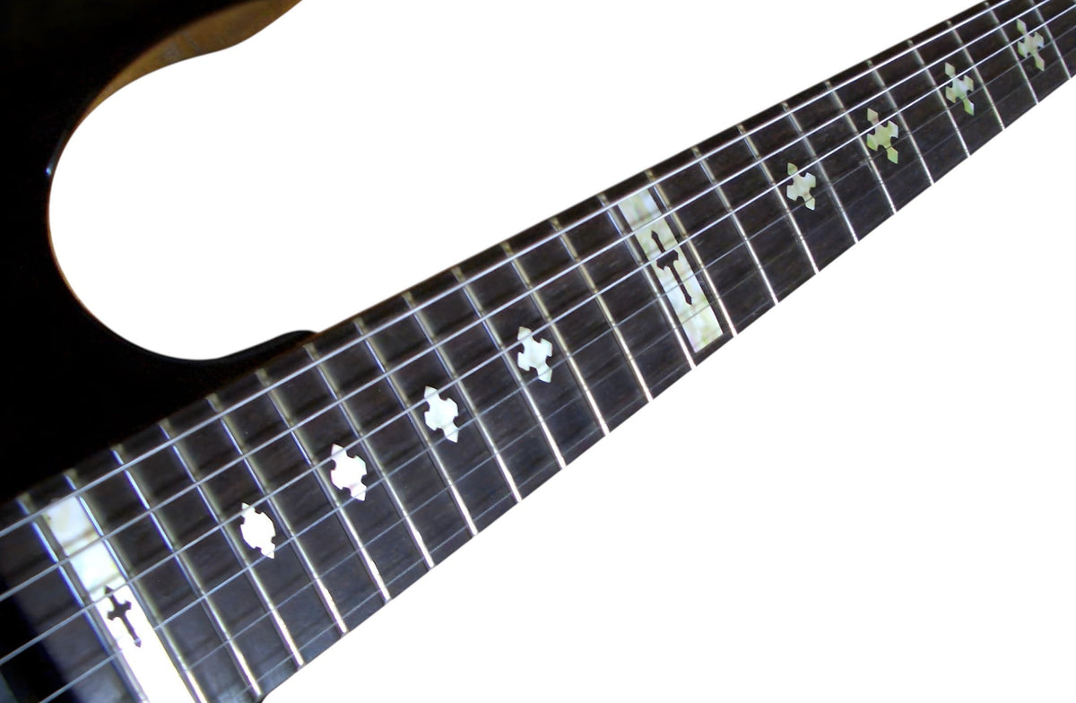 Close-up of a guitar neck with Cross fret markers